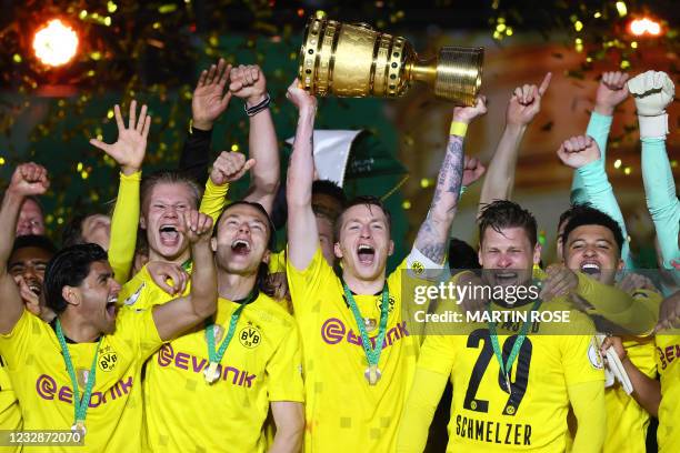 Dortmund's German forward Marco Reus holds the trophy as Dortmund's players celebrate after winning the German Cup final football match RB Leipzig v...