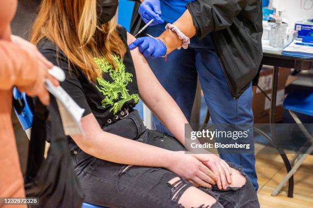 Healthcare worker administers a Covid-19 vaccine to a teenager at a vaccination site at a church in Long Beach, New York, on Thursday, May 13, 2021....