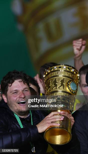 Dortmund's coach Edin Terzic holds the trophy as Dortmund's players celebrate after winning the German Cup final football match RB Leipzig v BVB...