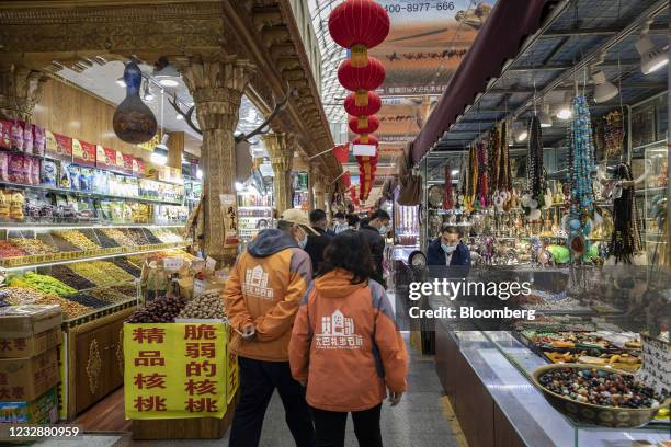 People walk past stalls at the Xinjiang International Grand Bazaar in Urumqi, Xinjiang province, China, on Wednesday, May 12, 2021. China has told...