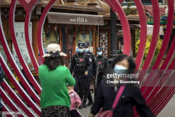 Squad of police officers wearing protective masks patrol the Xinjiang International Grand Bazaar in Urumqi, Xinjiang province, China, on Wednesday,...
