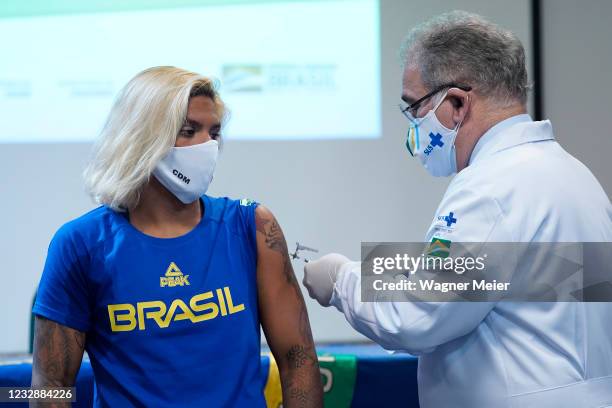 Brazilian athlete and marathon swimmer Ana Marcela Cunha from receives the first dose of Pfizer vaccine from Brazilian Health Minister Marcelo...