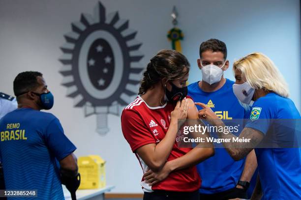 Brazilian athletes Ana Marcela Cunha, Marcus Vinícius D Almeida and Larissa de Oliveira talk after receiving their first dose of Pfizer vaccine as...