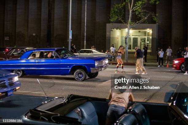 Van Nuys, CA Karla Ramirez sits in her familys 1963 Chevrolet Impala Super Sport while watching a man and a roller skater dance in the middle of the...