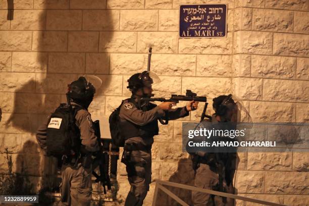 An Israeli soldier aims a tear gas gun in the Palestinian neighbourhood of Shuafat, neighbouring the Israeli settlement of Ramat Shlomo, in Israeli...