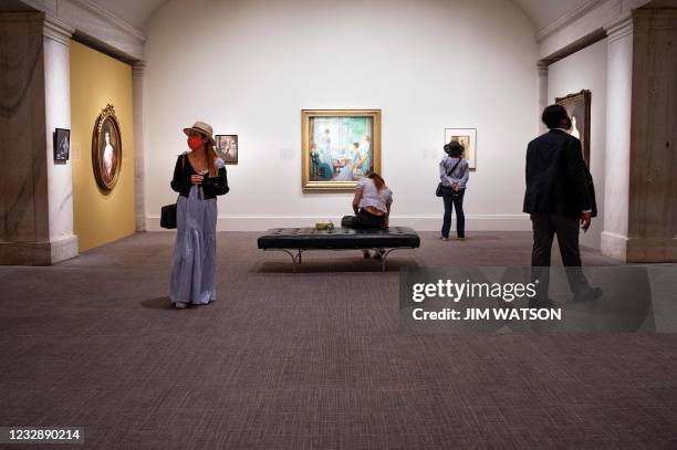 Tourists view an exhibit during the reopening of the Smithsonian National Portrait Gallery in Washington, DC, on May 14, 2021.