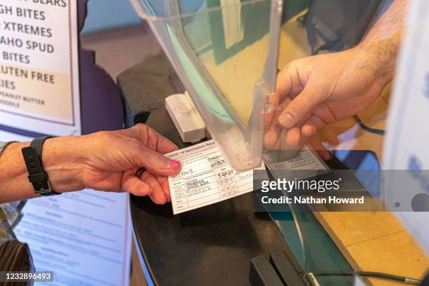 Susan Ford presents her vaccine card at Liberty Theatre on May 14, 2021 in Camas, Washington. Gov. Jay Inslee announced Thursday that the state-wide...