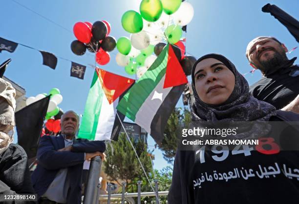 Palestinians attend a march to mark the 73rd anniversary of the Nakba, the "catastrophe" of Israel's creation in 1948, in the occupied West Bank city...
