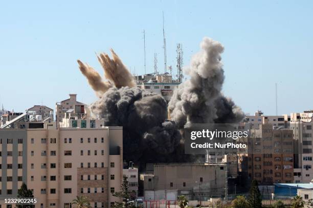 Thick column of smoke rises from the Jala Tower as it is destroyed in an Israeli airstrike in Gaza city controlled by the Palestinian Hamas movement,...