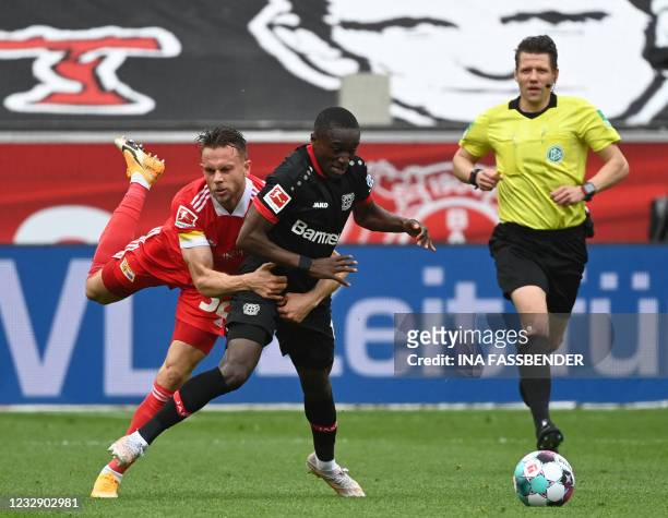 Union Berlin's Danish forward Marcus Ingvartsen and Leverkusen's French forward Moussa Diaby vie for the ball during the German first division...