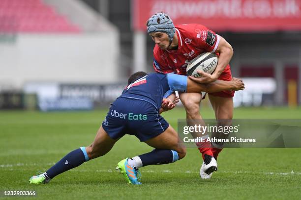 Jonathan Davies of Scarlets is tackled by Ben Thomas of Cardiff Blues during the Guinness Rainbow Cup match between the Scarlets and Cardiff Blues at...