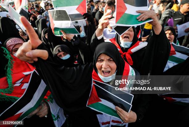 Iraqi women holding Palestinian flags in solidarity as they take part in a march in the capital Baghdad's Tahrir square, on May 15 on the 73rd...