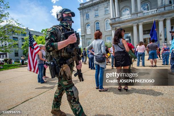 Armed members of the New England Minutemen militia group walk among rally goers during the anti-mask and anti-vaccine "World Wide Rally for Freedom"...