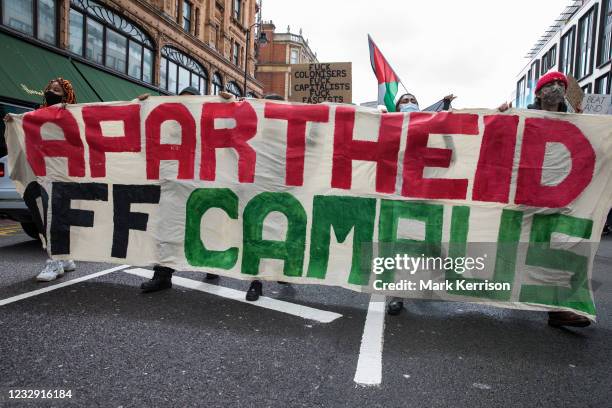 Protesters walk behind an Apartheid Off Campus banner during a Free Palestine SOS Colombia march in solidarity with the Palestinian and Colombian...