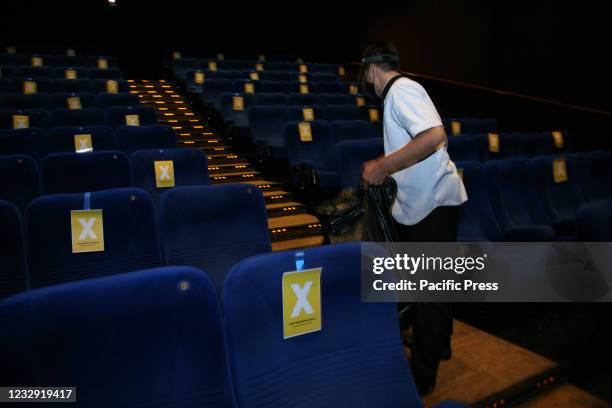 Cinema staff wear masks and face shields when cleaning empty seats in the XXI Cinema Theater, Kuningan area on the second day of the 2021 Eid...