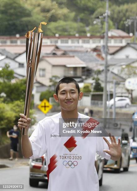 Tokyo Olympic torch relay participant runs in the Shimane Prefecture city of Oda, western Japan, on May 16, 2021.