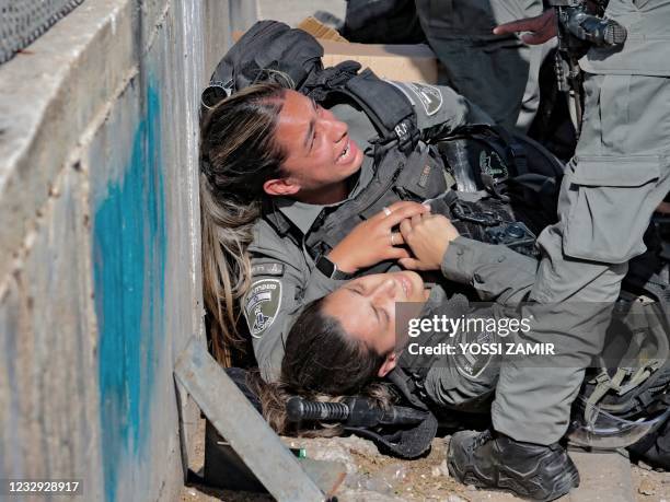 Israeli police officers react after being hit by a car in a ramming attack, in the Sheikh Jarrah neighbourhood of Israeli-annexed east Jerusalem, on...