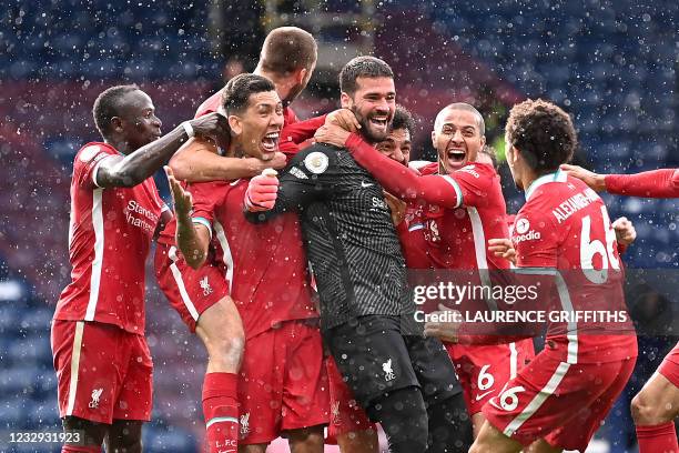 Liverpool's Brazilian goalkeeper Alisson Becker celebrates scoring his team's second goal with his teammates during the English Premier League...