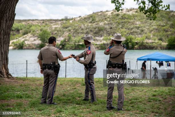 Texas State Troopers look across the river at a group of boys swimming in the Rio Grande near the border between Mexico and the United States in Del...