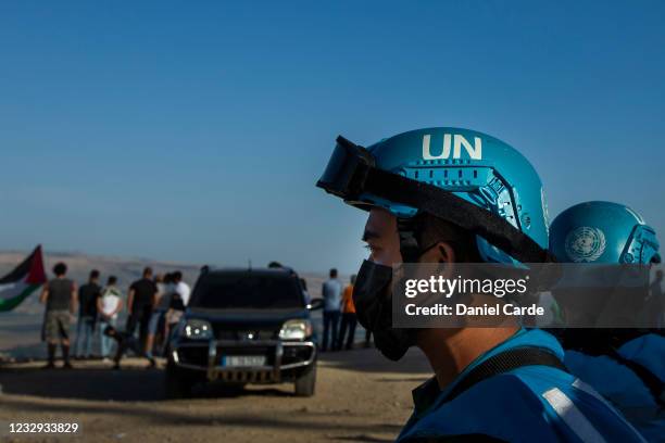United Nations peacekeeping force in Lebanon soldiers monitor as people hold demonstration to show solidarity with Palestinians near the...