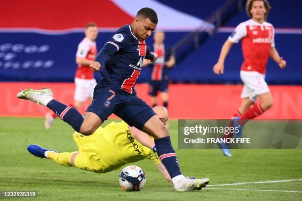 Paris Saint-Germain's French forward Kylian Mbappe is challenged by Reims' Serbian goalkeeper Predrag Rajkovic during the French L1 football match...