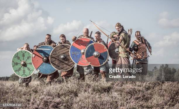 waffenschwingende wikingerkrieger in formation - vikings stock-fotos und bilder