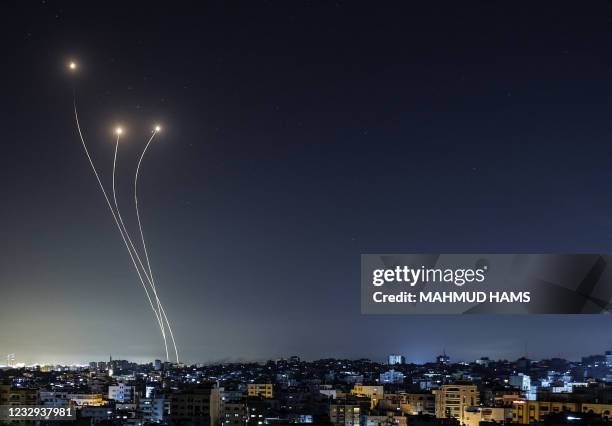 Streak of light appears as Israel's Iron Dome anti-missile system intercepts rockets launched from the Gaza Strip, early on May 17 - Israeli...