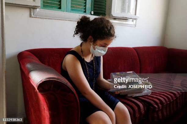Lebanese pupil Pamela uses her parents' mobile phone for an online lesson inside a crammed apartment in the eastern Beirut suburb of Burj Hammoud, on...