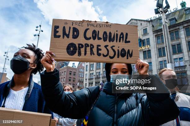Black woman seen holding a placard over her head against the colonialism during the demonstration. The Netherlands and thousands of Dutch people...