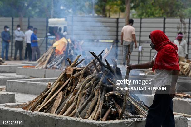 Priest performs last rites of a person who died due to the Covid-19 coronavirus at a cremation ground in New Delhi on May 17, 2021.