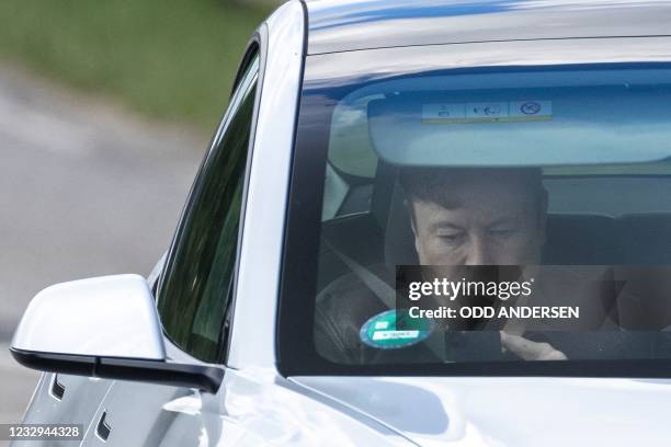 Tesla CEO Elon Musk uses his mobile device as he sits in the car arriving to the construction site for the new plant, the so-called "Giga Factory",...