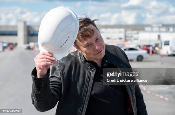 May 2021, Brandenburg, Grünheide: Elon Musk, Tesla CEO, stands on the construction site of the Tesla factory and greets with his hard hat. He has...