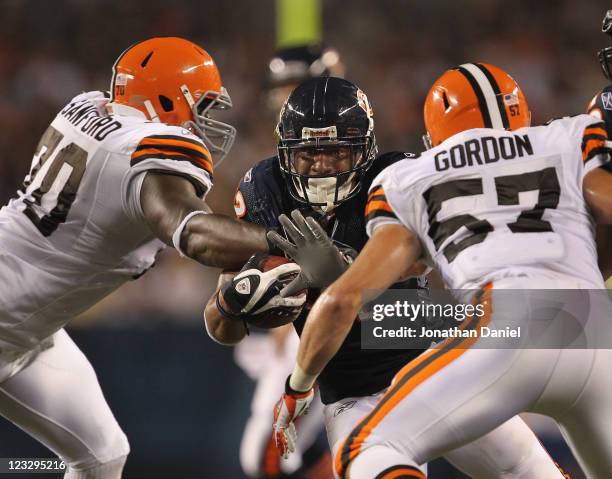 Kahlil Bell of the Chicago Bears runs against Brian Sanford and Eric Gordon of the Cleveland Browns during a preseason game at Soldier Field on...