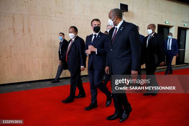 French President Emmanuel Macron walks with Sudan's Sovereign Council Chief General Abdel Fattah al-Burhan and Sudan's Prime Minister Abdalla Hamdok...