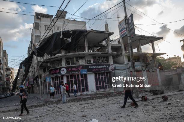 People inspect the rubble of destroyed commercial building and Gaza health care clinic following an Israeli airstrike on the upper floors of a...