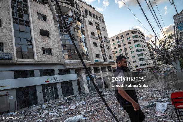 People inspect the rubble of destroyed commercial building and Gaza health care clinic following an Israeli airstrike on the upper floors of a...