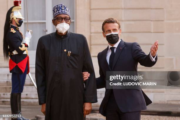 France's President Emmanuel Macron welcomes Nigeria's President Muhammadu Buhari upon his arrival for a dinner at the Elysee Presidential Palace in...