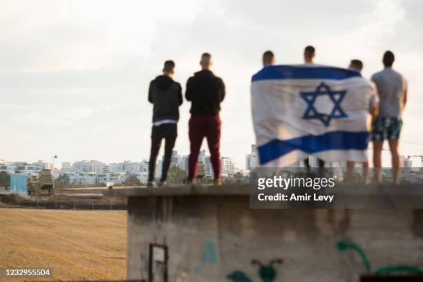 Israelis gather to watch the Iron Dome missile defence system launch to intercept rockets fire from the Gaza Strip on May 17, 2021 in Ashdod, Israel....