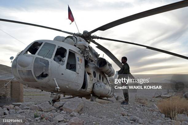 In this photograph taken on March 25 an Afghan National Army soldier stands next to a damaged helicopter which was shot down by the Taliban near the...