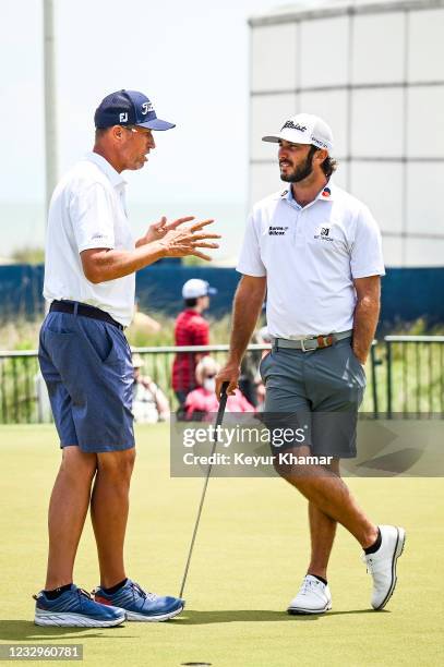 Max Homa speaks with his temporary caddie Jim Bones Mackay on the putting green during practice for the PGA Championship on The Ocean Course at...