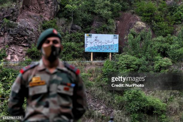An Indian army officer stands near the Aman Setu bridge as Pakistan flag is seen on the other side on LoC in URI sector of District Baramulla, Jammu...