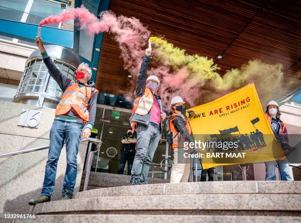 Protestors hold smoke flares as they take part in an action called by global environmental movement Extinction Rebellion and Dutch climate activist...