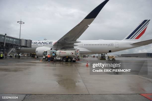 Staff members refuel an Airbus A350-900, the first Air France jet long-haul aircraft fuelled with sustainable aviation fuel produced by French energy...