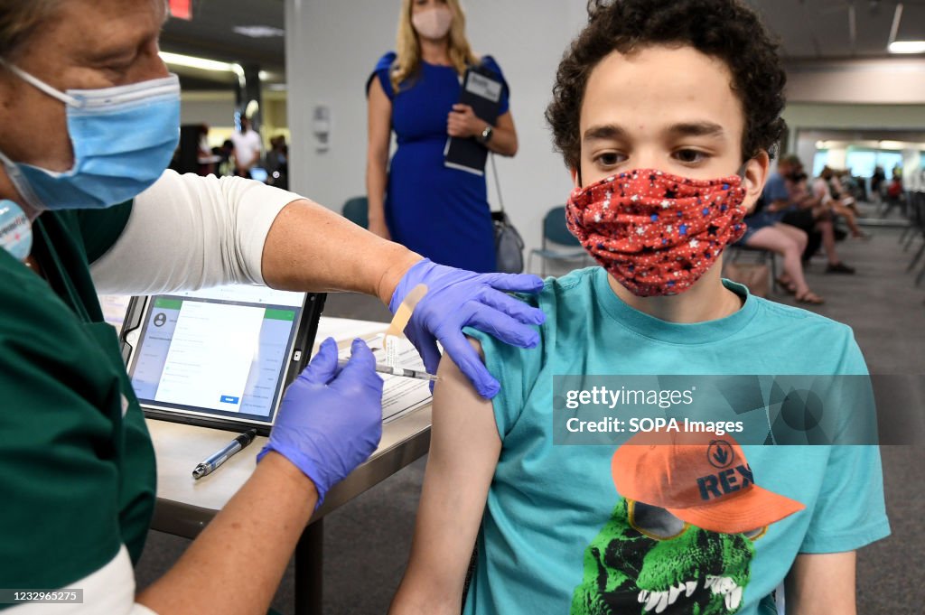 A nurse gives Malikai McPherson, 16,  a shot of the vaccine...