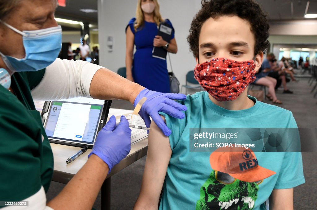 A nurse gives Malikai McPherson, 16, a shot of the vaccine...