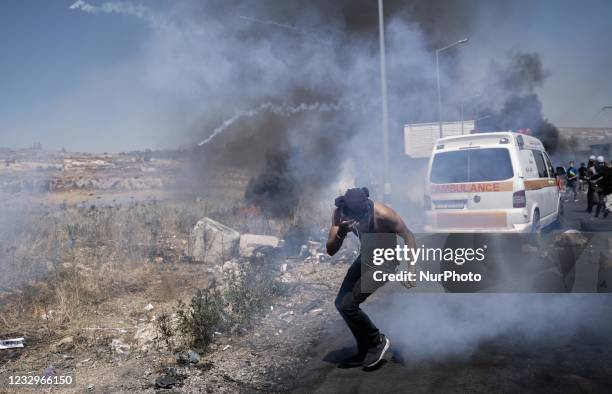 Palestinian protestor runs for shelter from tear gas fired by Israeli soldiers during clashes near the Jewish settlement of Beit El near Ramallah,...