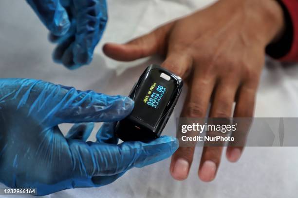 Health worker uses Oximeter to check the Oxygen Level of a Person at a School Turned COVID-19 Center in Uri, Baramulla, Jammu and Kashmir, India on...