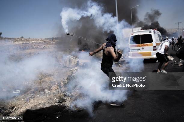 Palestinian demonstrator throws teargas canisters back at Israeli forces during clashes near the Jewish settlement of Beit El near Ramallah, West...