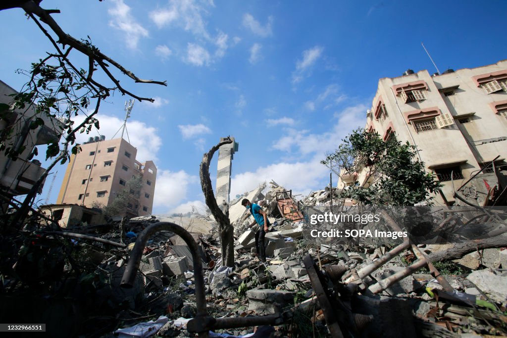 A Palestinian boy inspects his destroyed house after being...