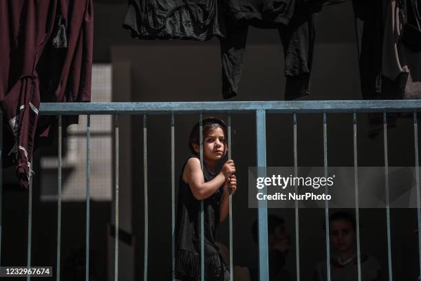 Palestinians, who fled their home due to Israeli air and artillery strikes, sit at a United Nations-run school where they take refuge, in Gaza City...